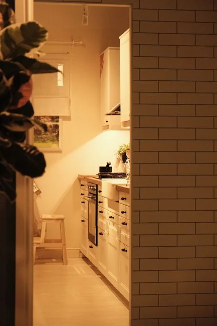 Anonymous male wearing yellow latex gloves and dark t shirt wiping mirror in bathroom with paper napkin